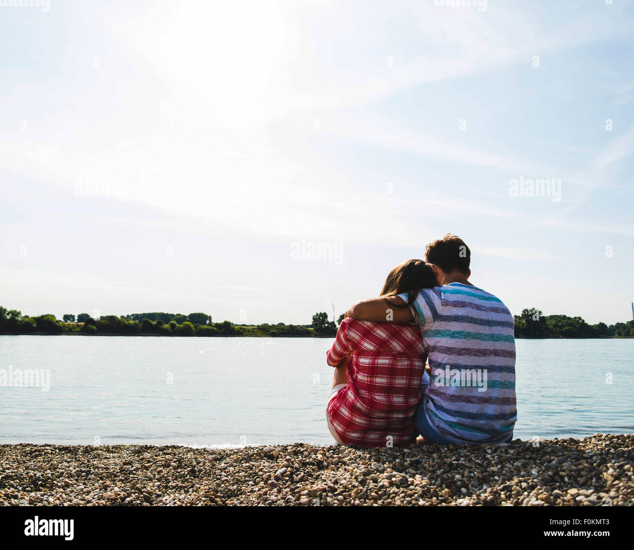 Young couple sitting by the riverside Stock Photo