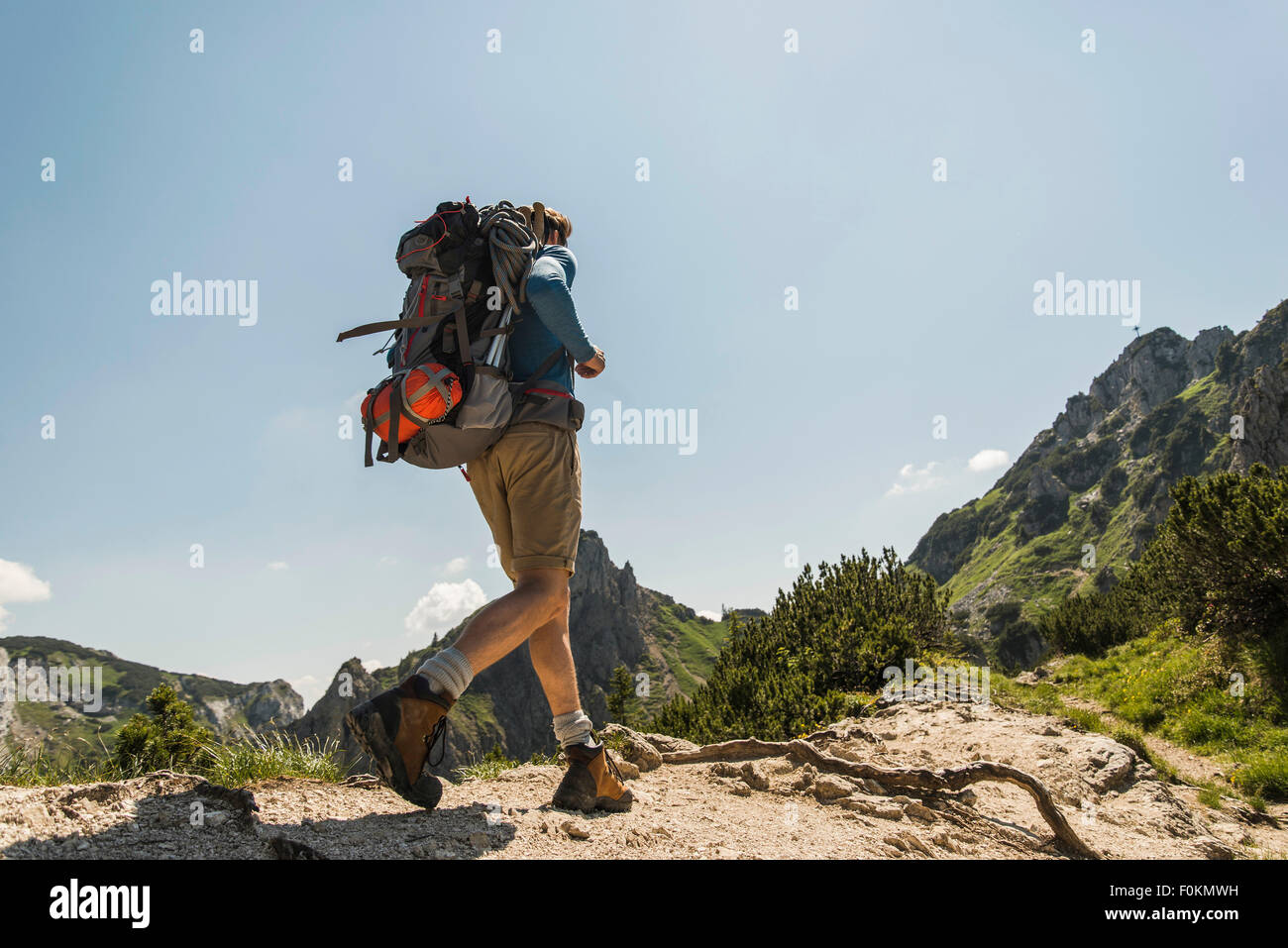 Austria, Tyrol, Tannheimer Tal, young man hiking on mountain trail Stock Photo