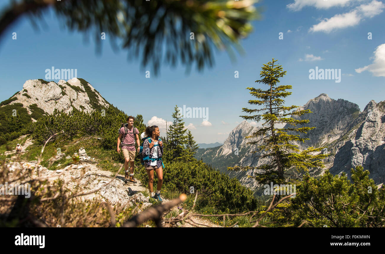 Austria, Tyrol, Tannheimer Tal, young couple hiking on mountain trail Stock Photo