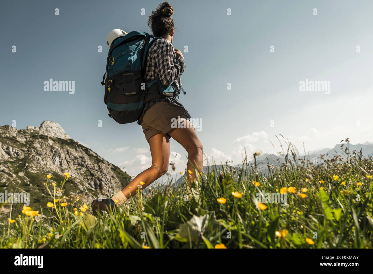 Austria, Tyrol, Tannheimer Tal, young woman hiking on alpine meadow Stock Photo