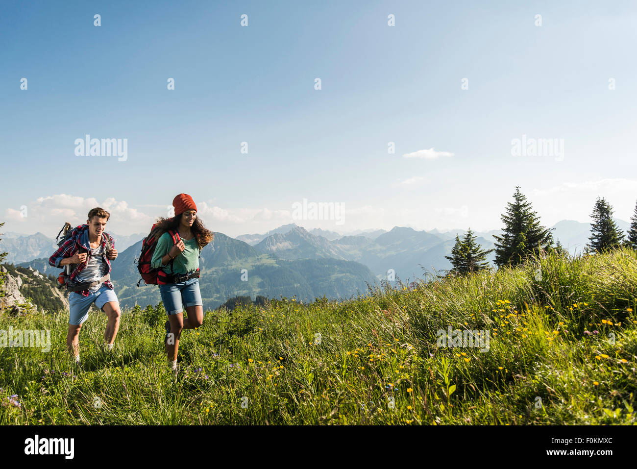 Austria, Tyrol, Tannheimer Tal, young couple hiking on alpine meadow Stock Photo