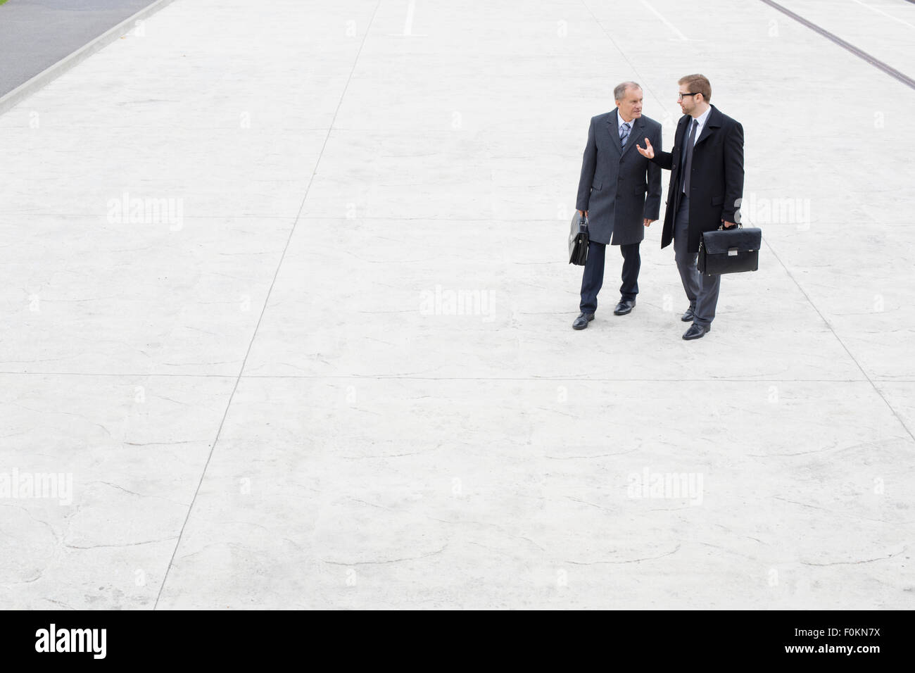 Two businessmen walking and talking outdoors Stock Photo - Alamy