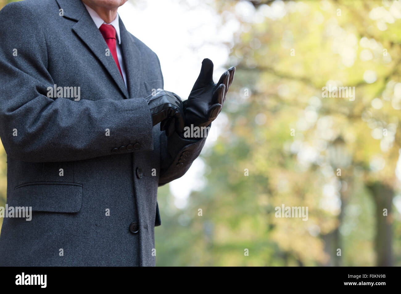 Businessman outdoors putting on gloves Stock Photo