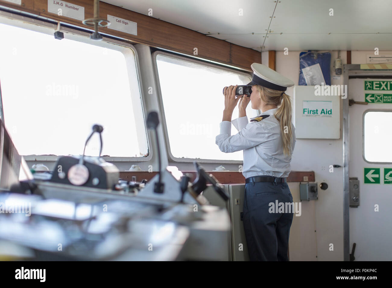 Deck officer on ship looking through binoculars Stock Photo