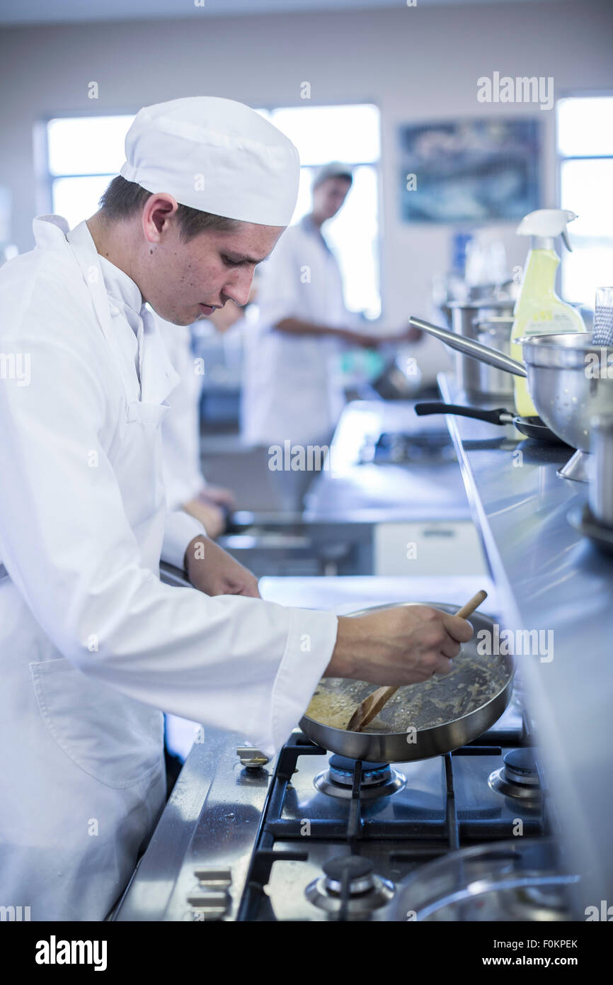 Teenager cooking in canteen kitchen Stock Photo Alamy