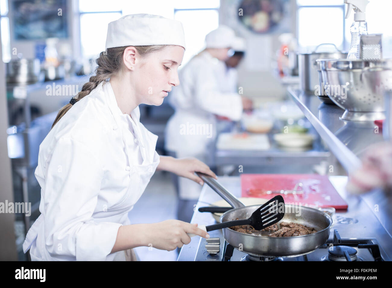 Teenage girl cooking in canteen kitchen Stock Photo Alamy