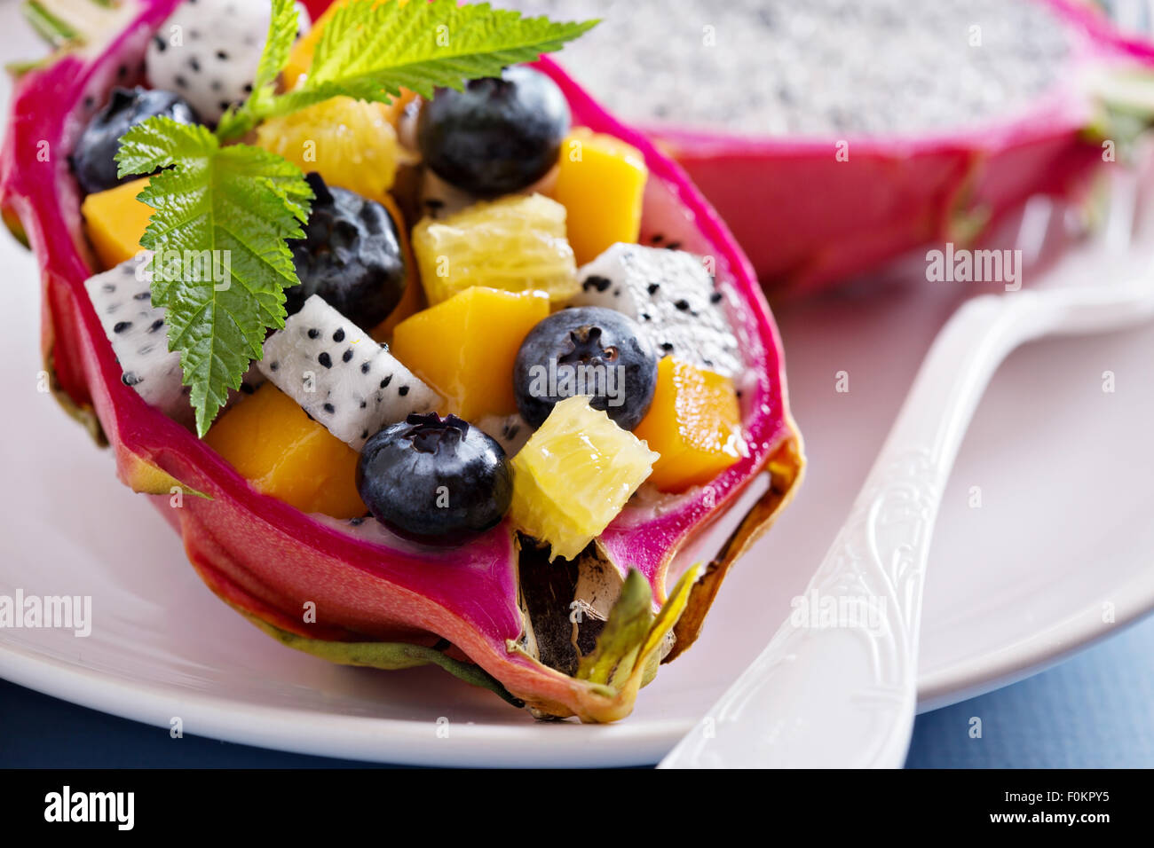 Tropical fruit salad served inside a dragon fruit Stock Photo