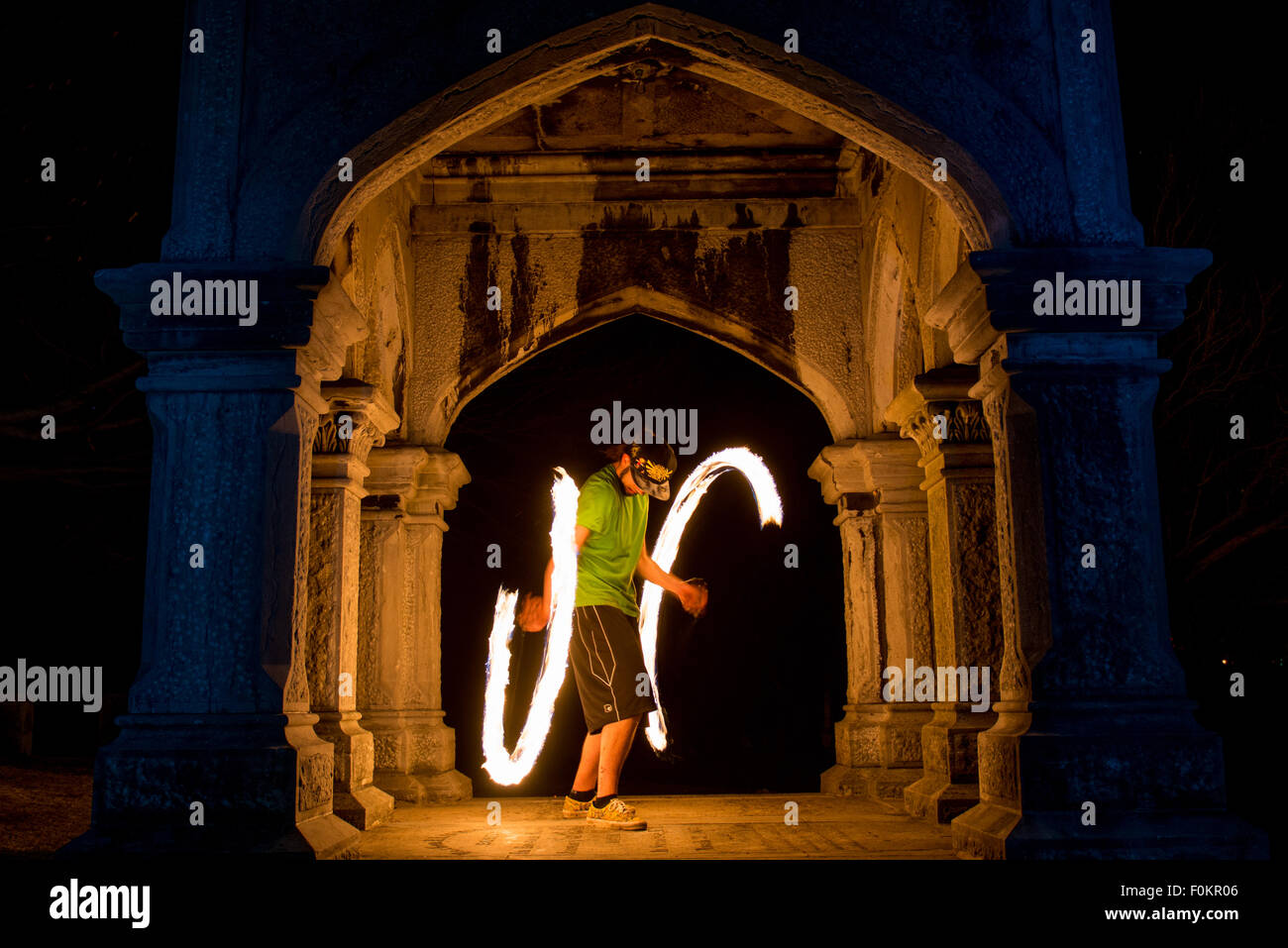 A college student spins and juggles fire in Oakwood Cemetery in Syracuse, New York. Stock Photo