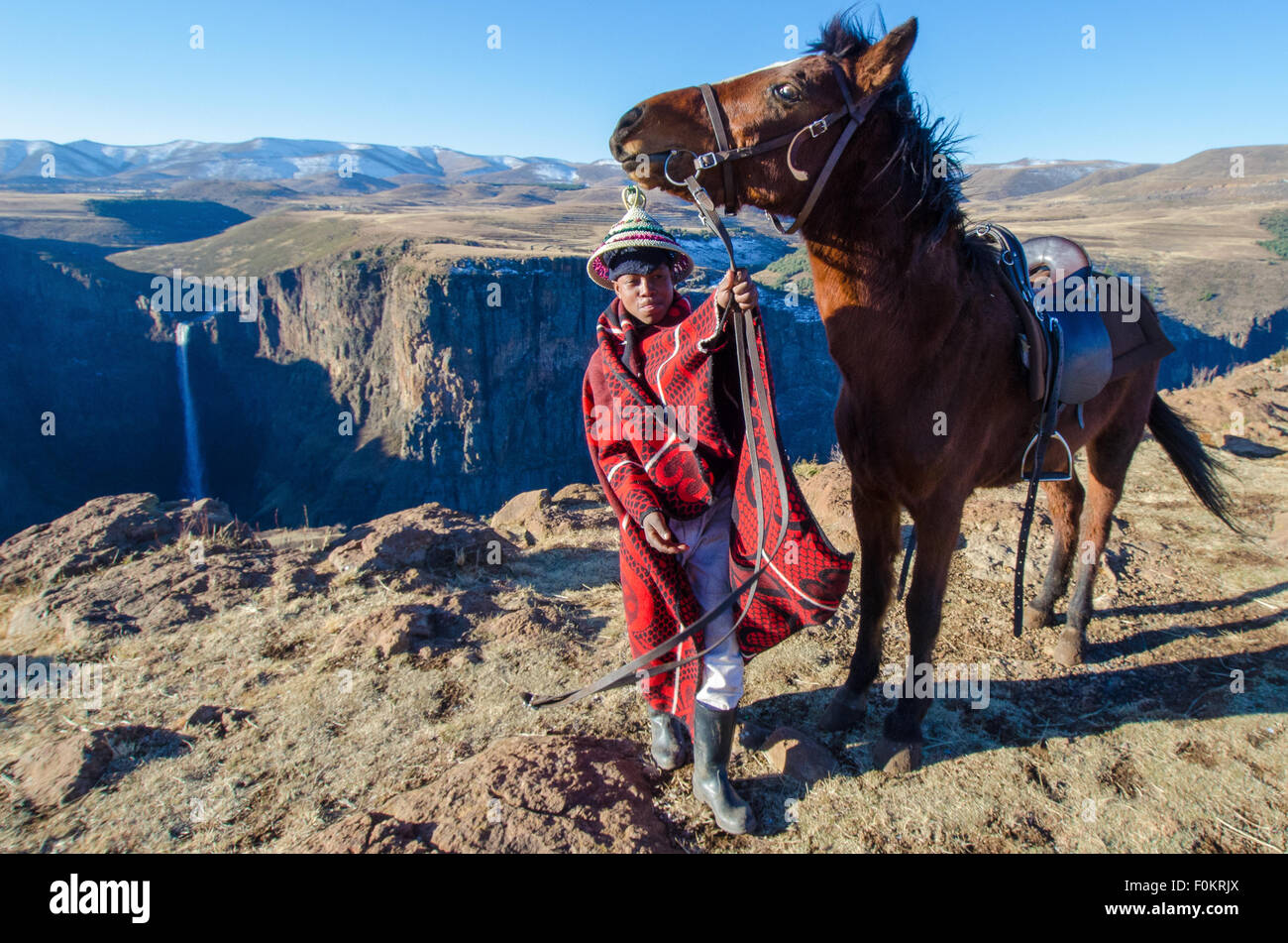 A young shepherd guides his horse along the cliffs of Lesotho near Maletsunyane Falls. Stock Photo