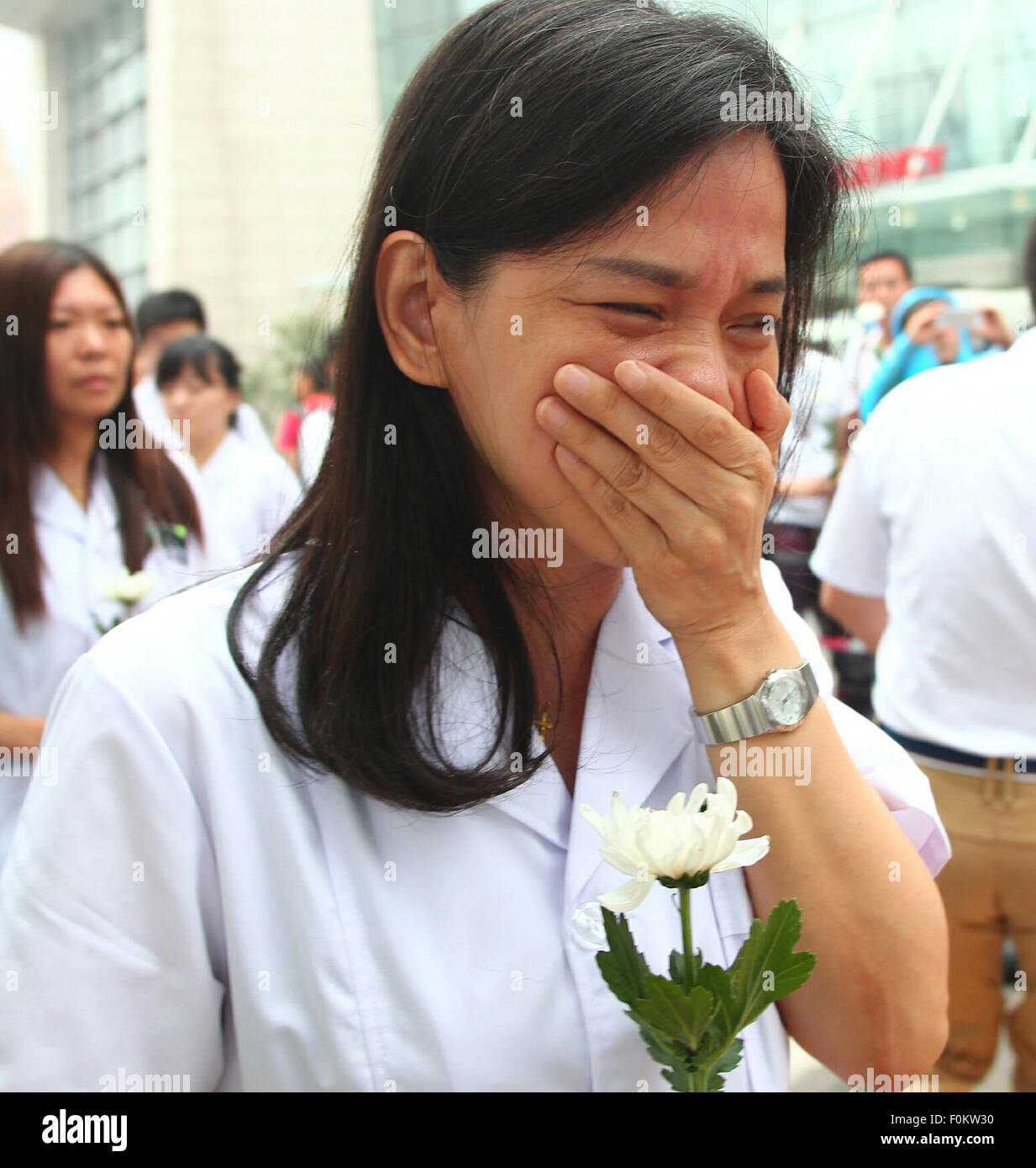 Tianjin, China. 18th Aug, 2015. A medical staff member cries while mourning for the victims of the massive warehouse explosions at Taida Hospital near the explosion site in Tianjin, north China, Aug. 18, 2015. The death toll from last week's massive blasts in Tianjin rose to 114. Credit:  Chen Yichen/Xinhua/Alamy Live News Stock Photo