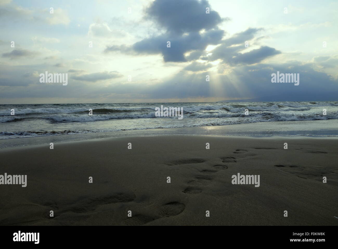 Footprints in the sand and shining light from heaven Stock Photo