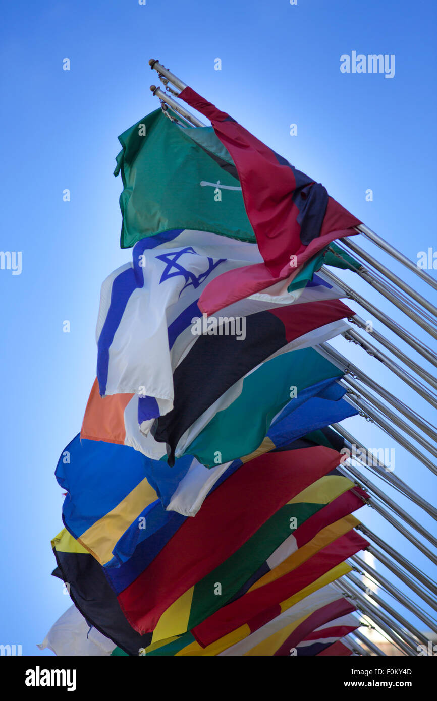 Group of flags of many different nations against blue sky Stock Photo