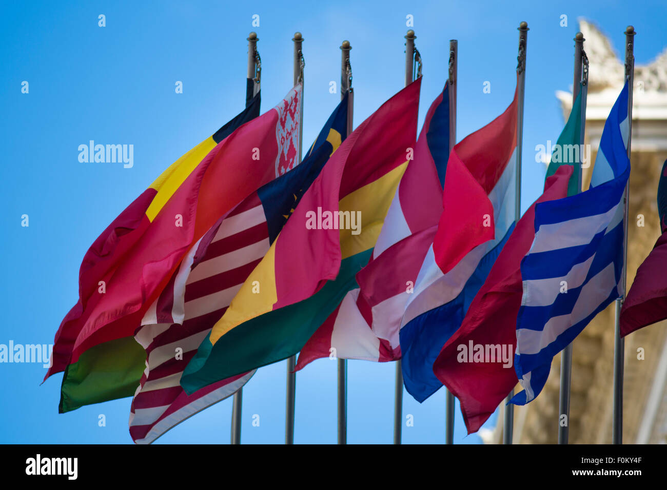 Group of flags of many different nations against blue sky Stock Photo