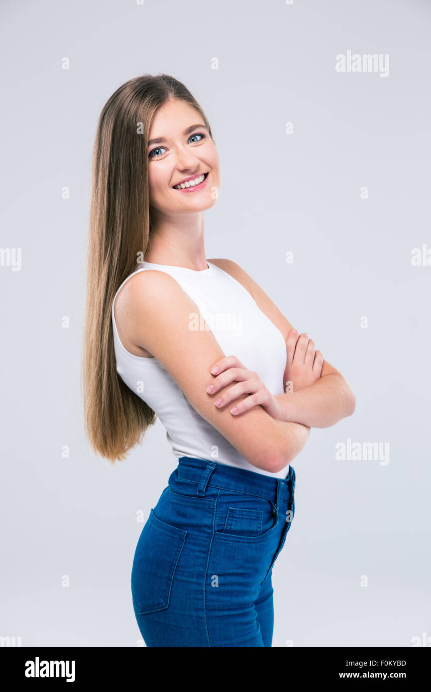 Portrait of a smiling female teenager standing with arms folded isolated on a white background. Looking at camera Stock Photo