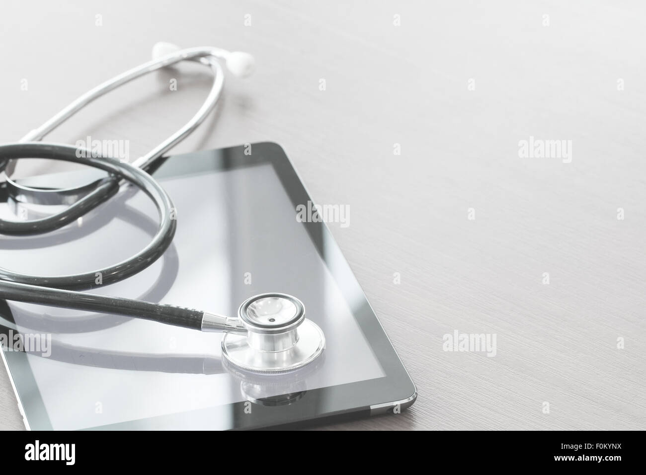 Studio macro of a stethoscope and digital tablet abstract on wood table ...