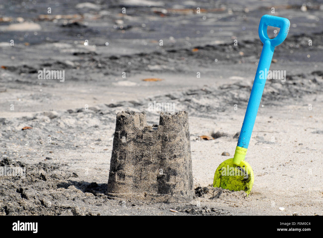 Sand castle and a plastic shovel at a beach Stock Photo