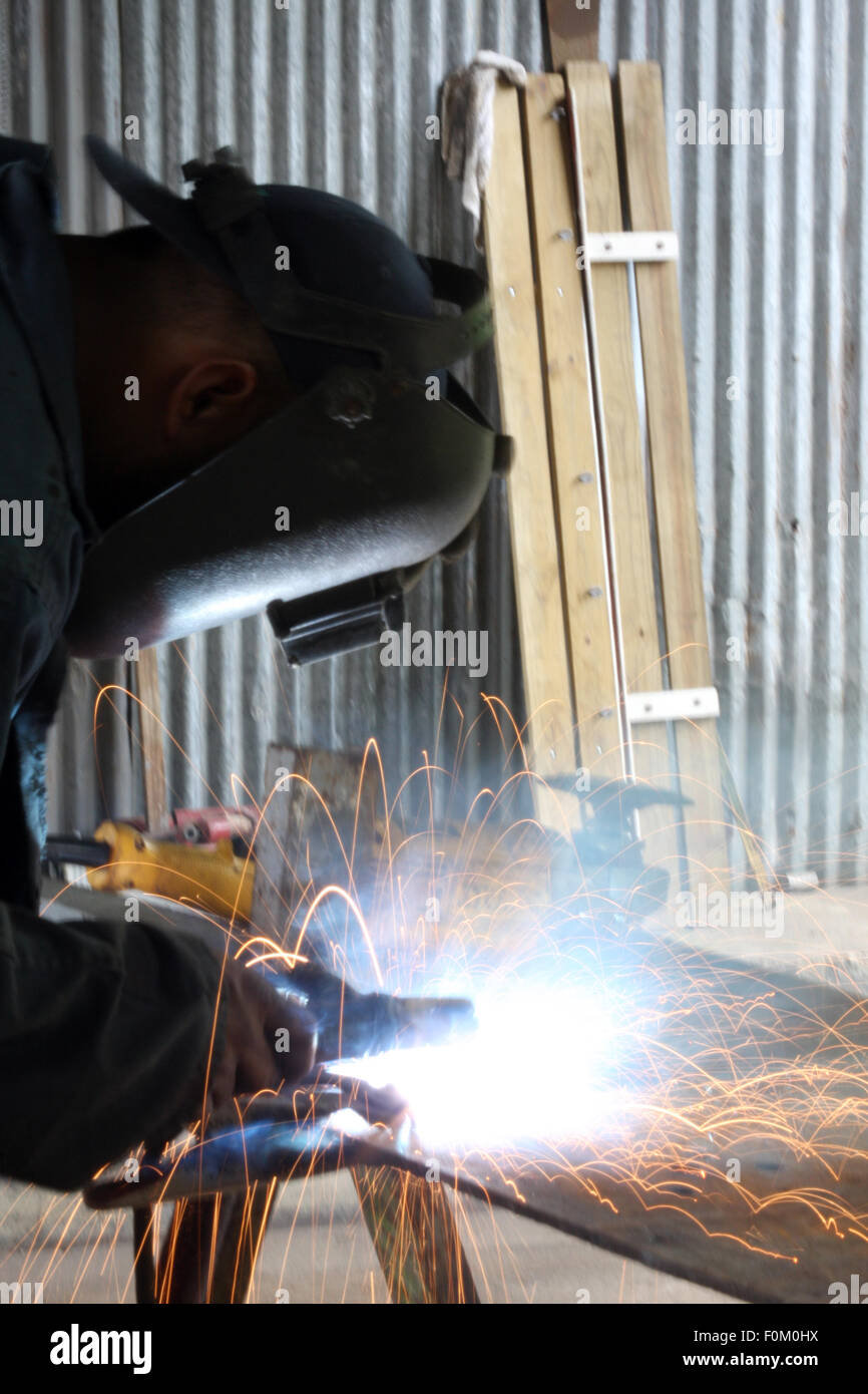 Man welding a piece of iron on a work table Stock Photo