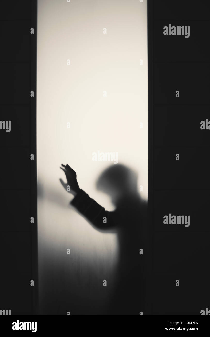Silhouette of little child with raised arm. Conceptual image of childhood fears, abuse and safety of children. Stock Photo