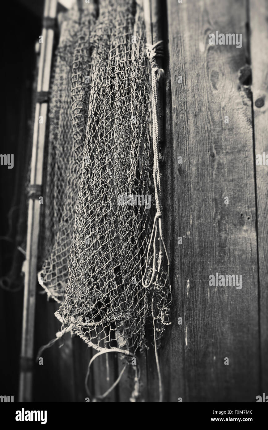 Still life with old fashioned fishing net hanging on wooden wall Stock  Photo - Alamy