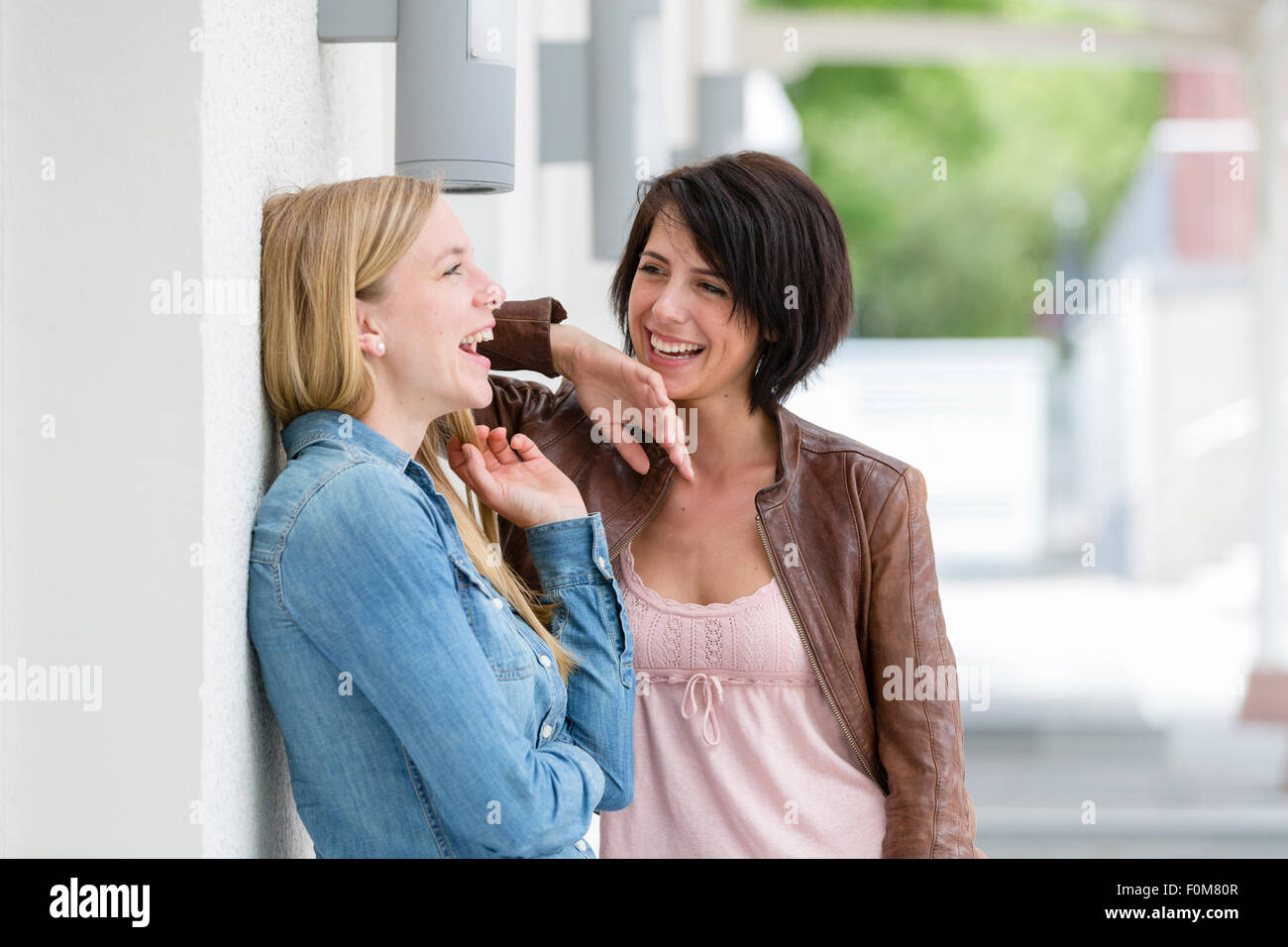 Two girlfriends laugh together and talk Stock Photo