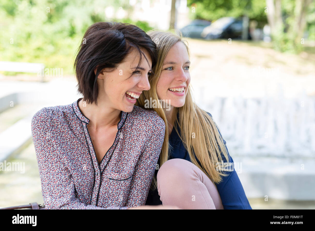 Two girlfriends laugh together and talk Stock Photo