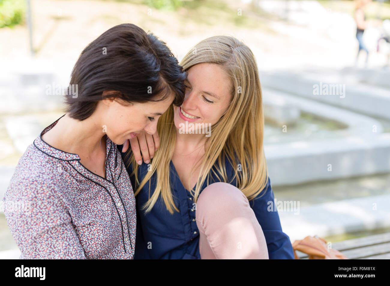 Two girlfriends laugh together and talk Stock Photo