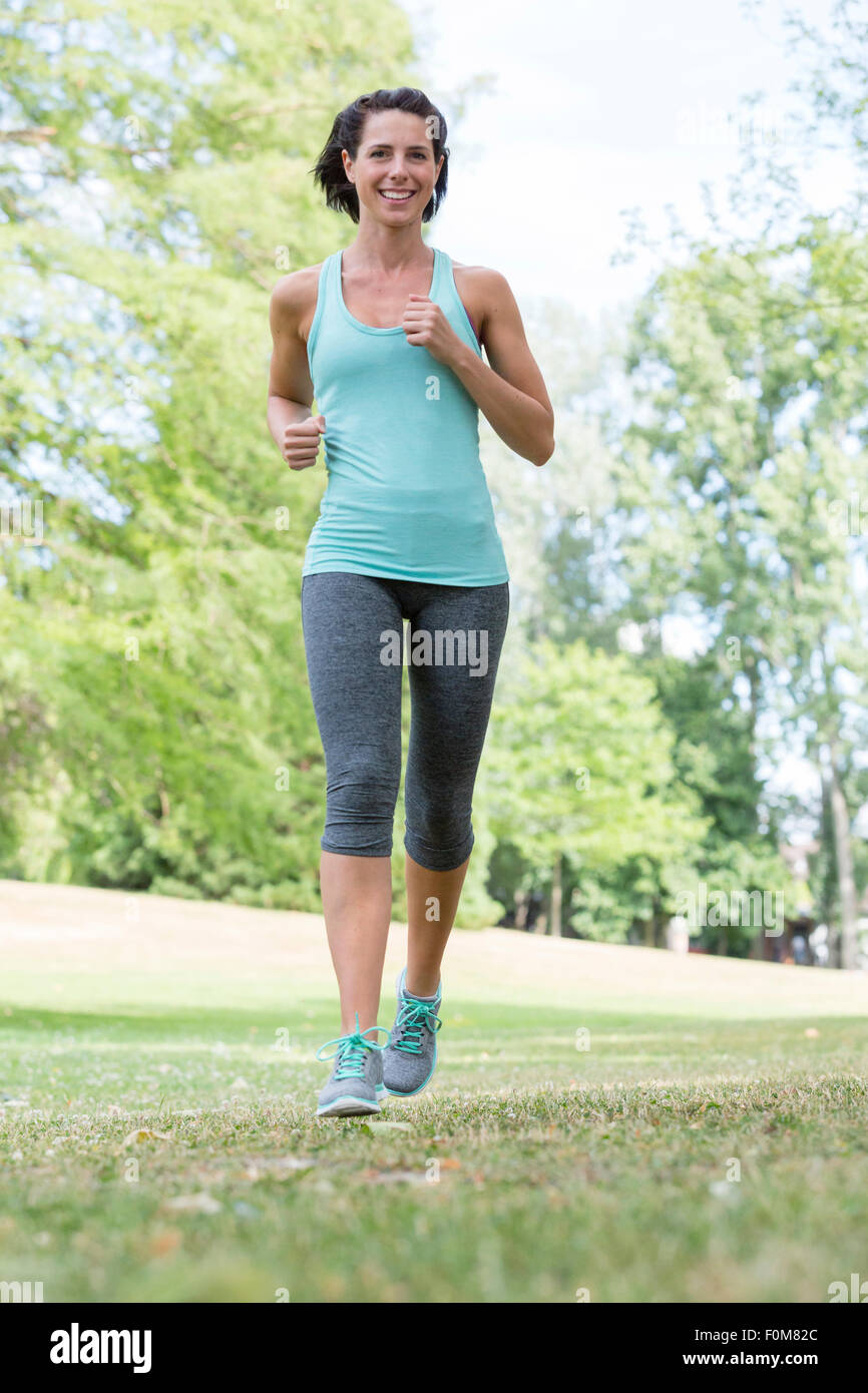Woman jogging through the park Stock Photo