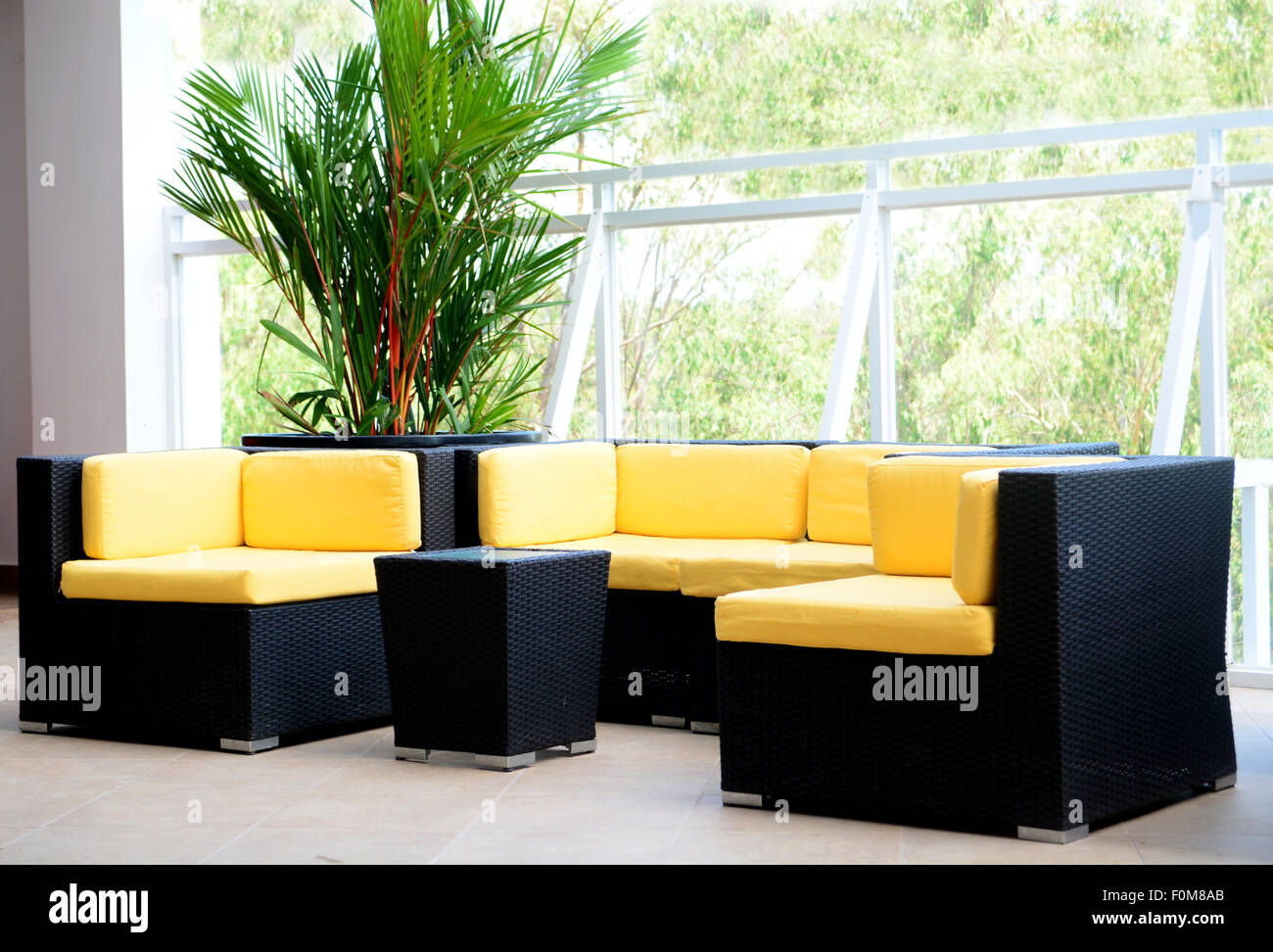Hotel deck interior furniture with black sofa and chairs and yellow pillows Stock Photo