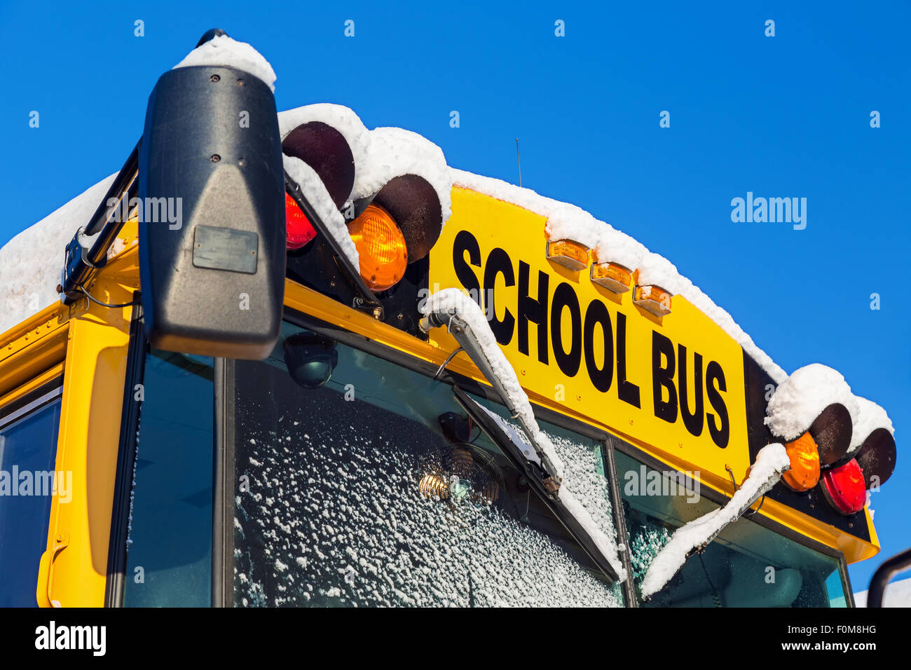 The front of a school bus after a fresh winter snowfall. Stock Photo