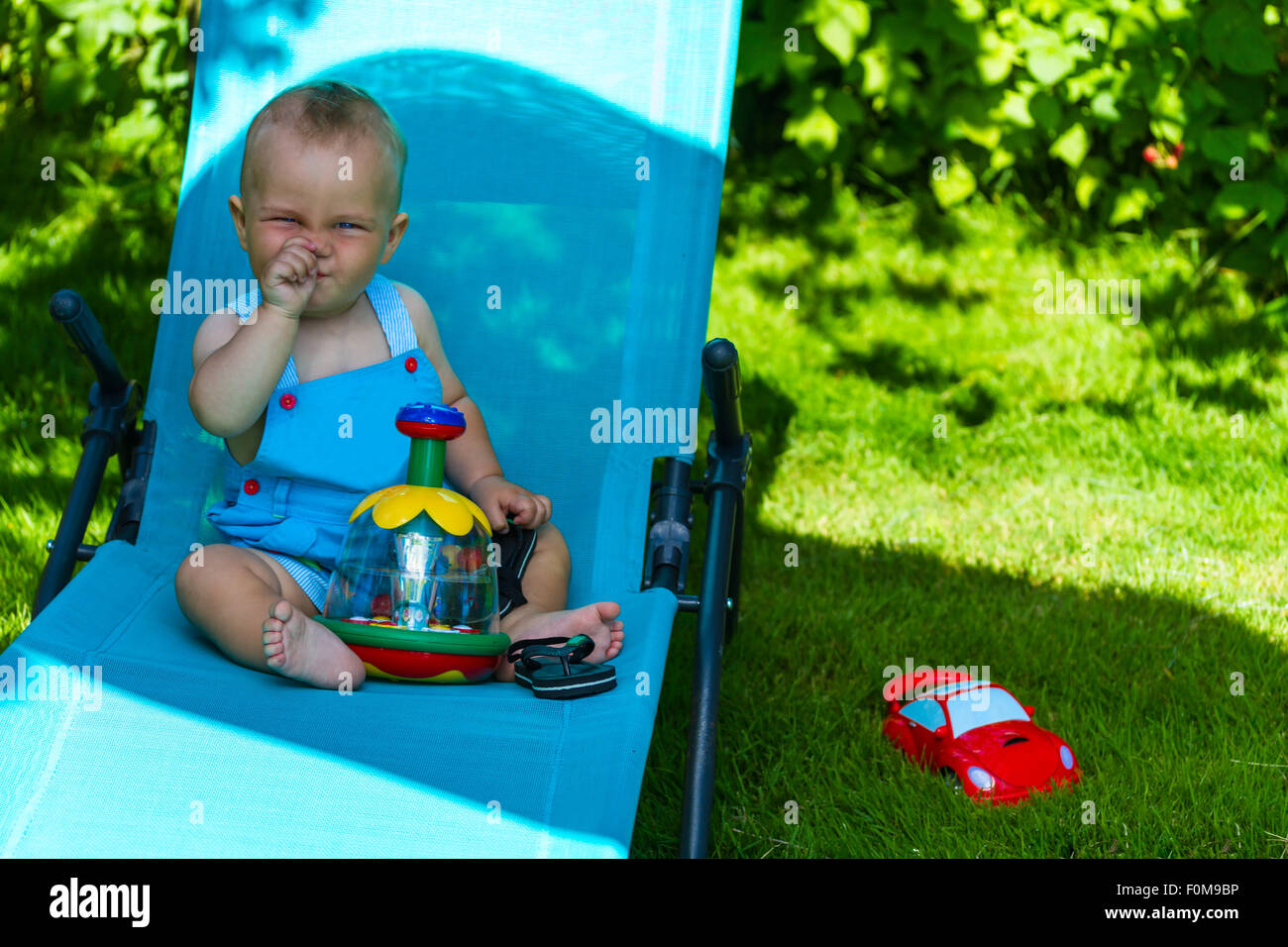 charming caucasian baby boy on chaise lounge in park Stock Photo Alamy