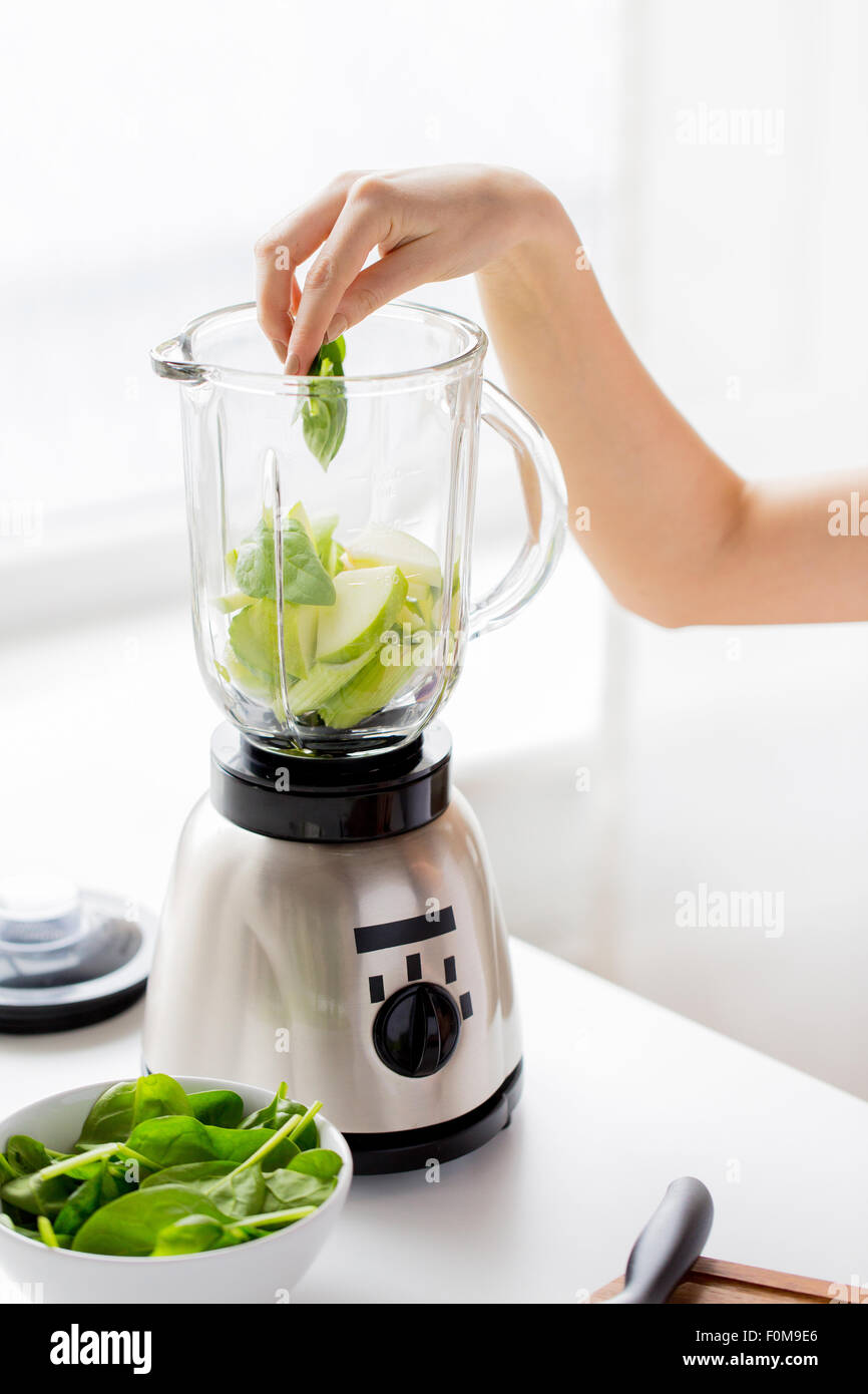 close up of woman hand with blender and vegetables Stock Photo