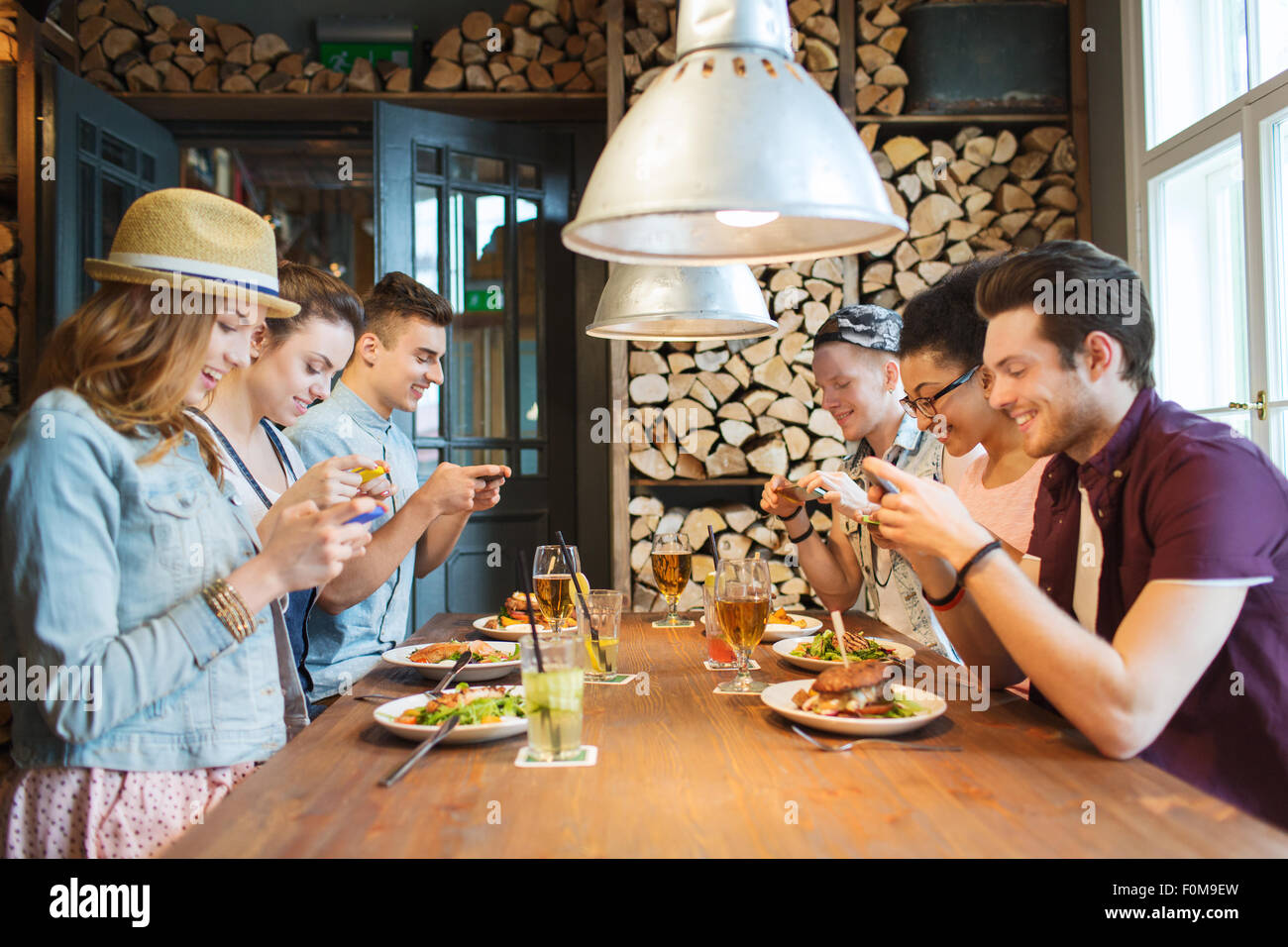 happy friends with smartphones picturing food Stock Photo