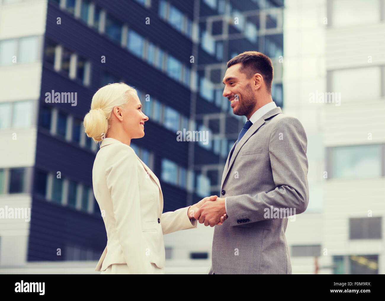 smiling businessmen standing over office building Stock Photo - Alamy