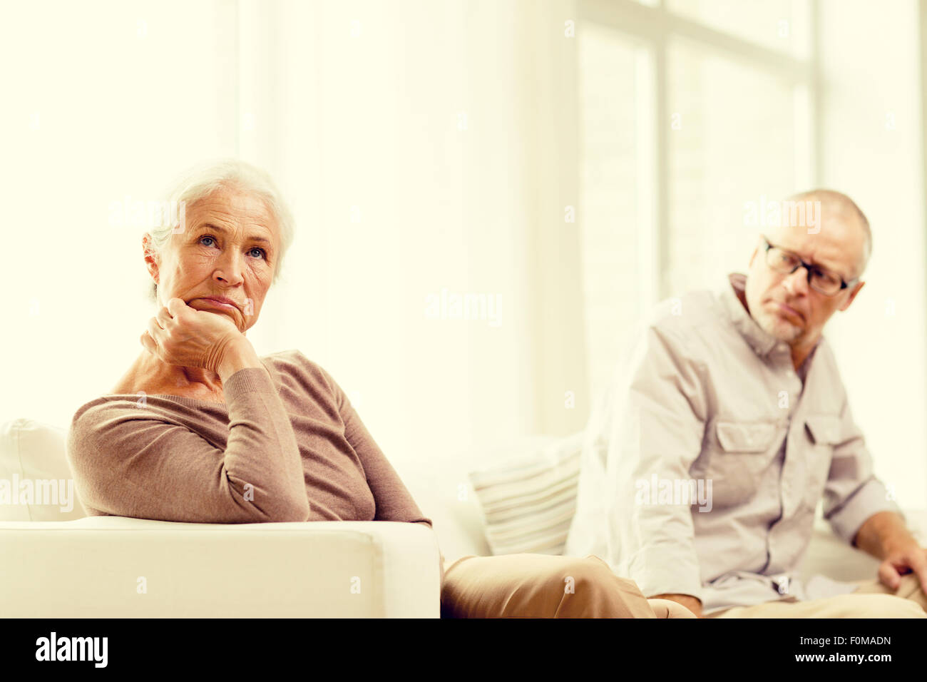 senior couple sitting on sofa at home Stock Photo