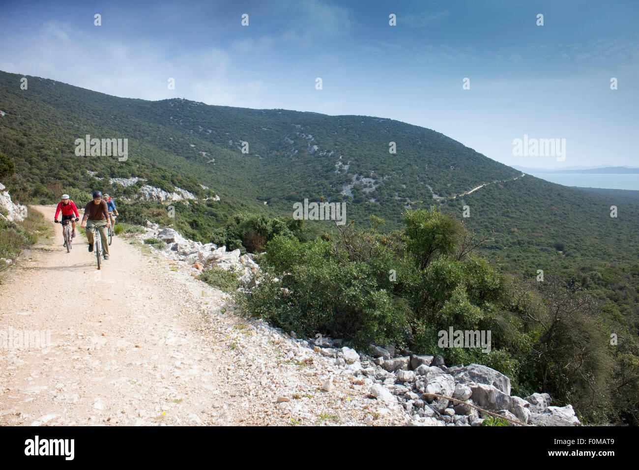 Cyclists on a dirt road near Vransko Jezero lake Croatia Stock Photo