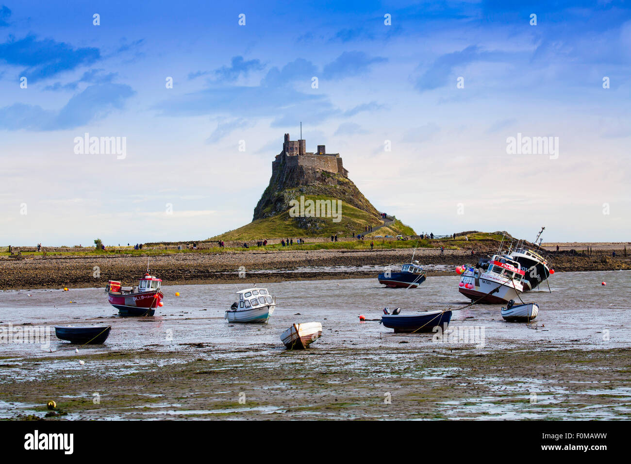 Skiffs at low tide in front of the castle on Holy Island, Lindisfarne, Northumberland, England, UK Stock Photo