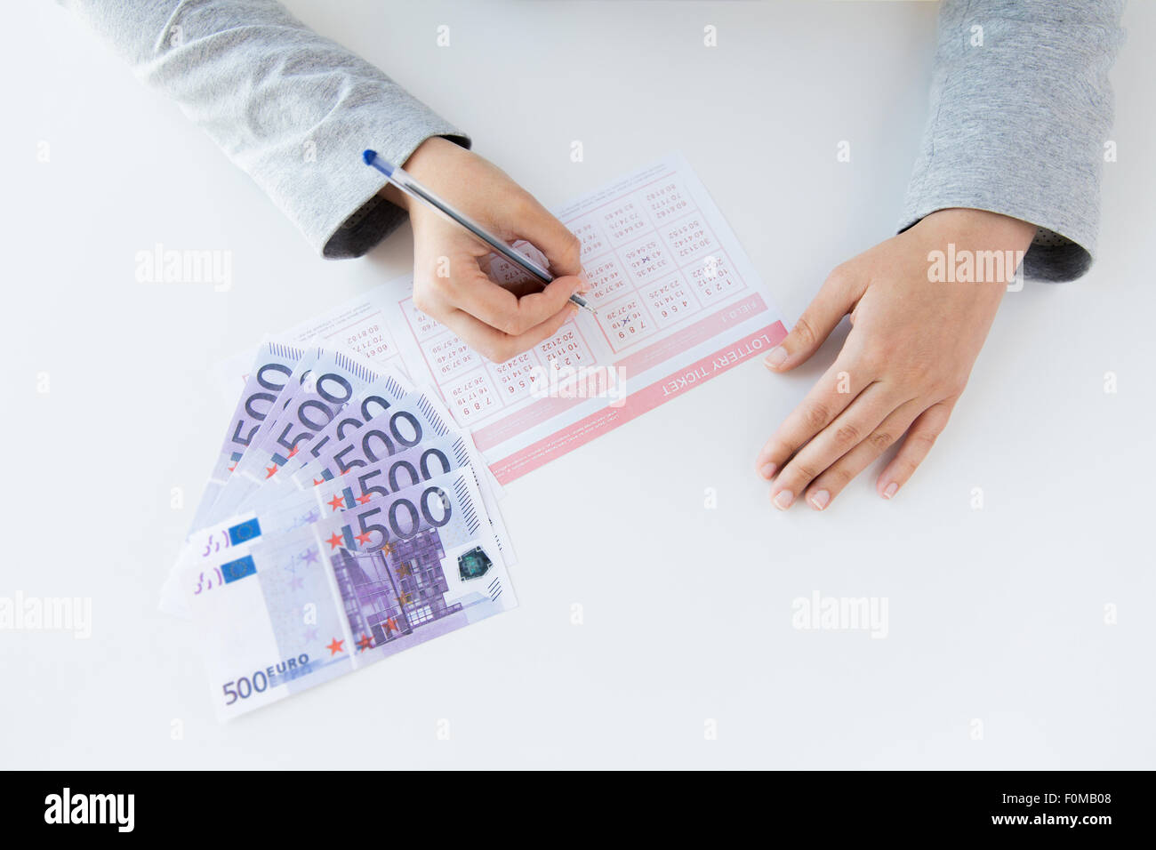 close up of hands with lottery ticket and money Stock Photo
