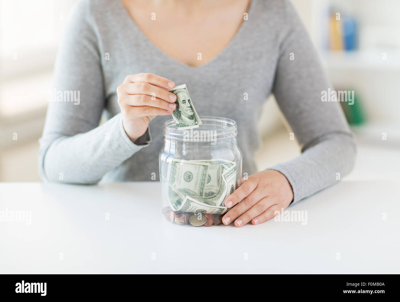 close up of woman hands and dollar money in jar Stock Photo