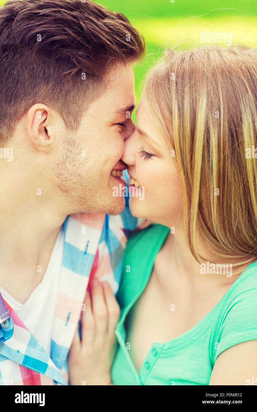 smiling couple kissing and hugging in park Stock Photo - Alamy