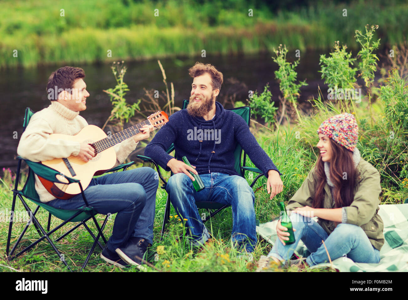 group of tourists playing guitar in camping Stock Photo