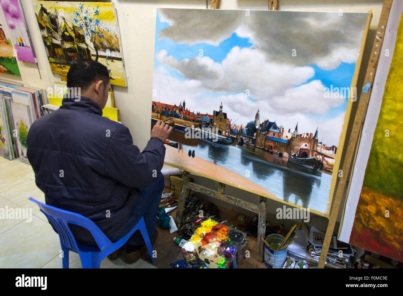 a Vietnamese painter is duplicating a painting from internet Stock Photo
