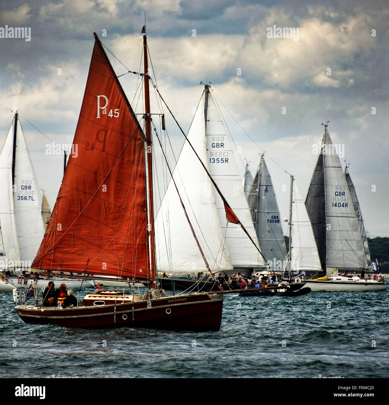 An old gaffer sailing vessel cruises against the traffic at the start of the Fastnet Race 2015 at Cowes, Isle of Wight Stock Photo