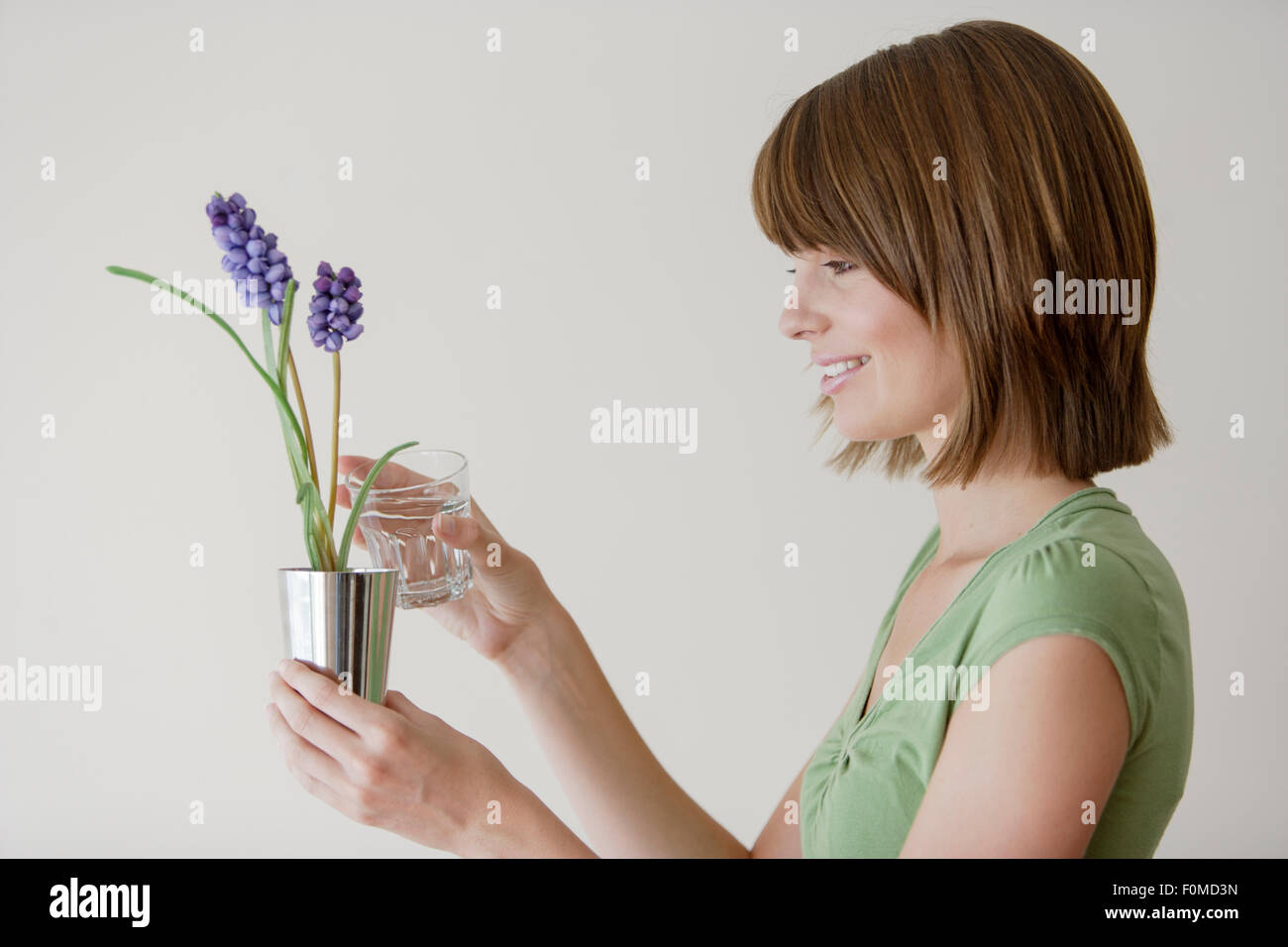 Young woman holding a plant in a studio Stock Photo - Alamy