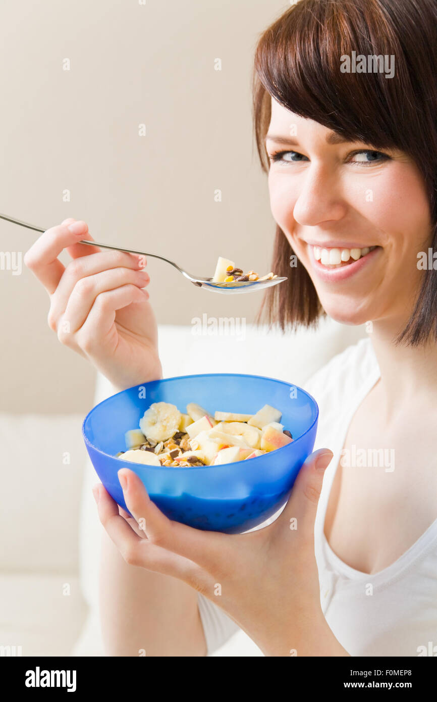 Young woman eating a bowl of muesli Stock Photo Alamy
