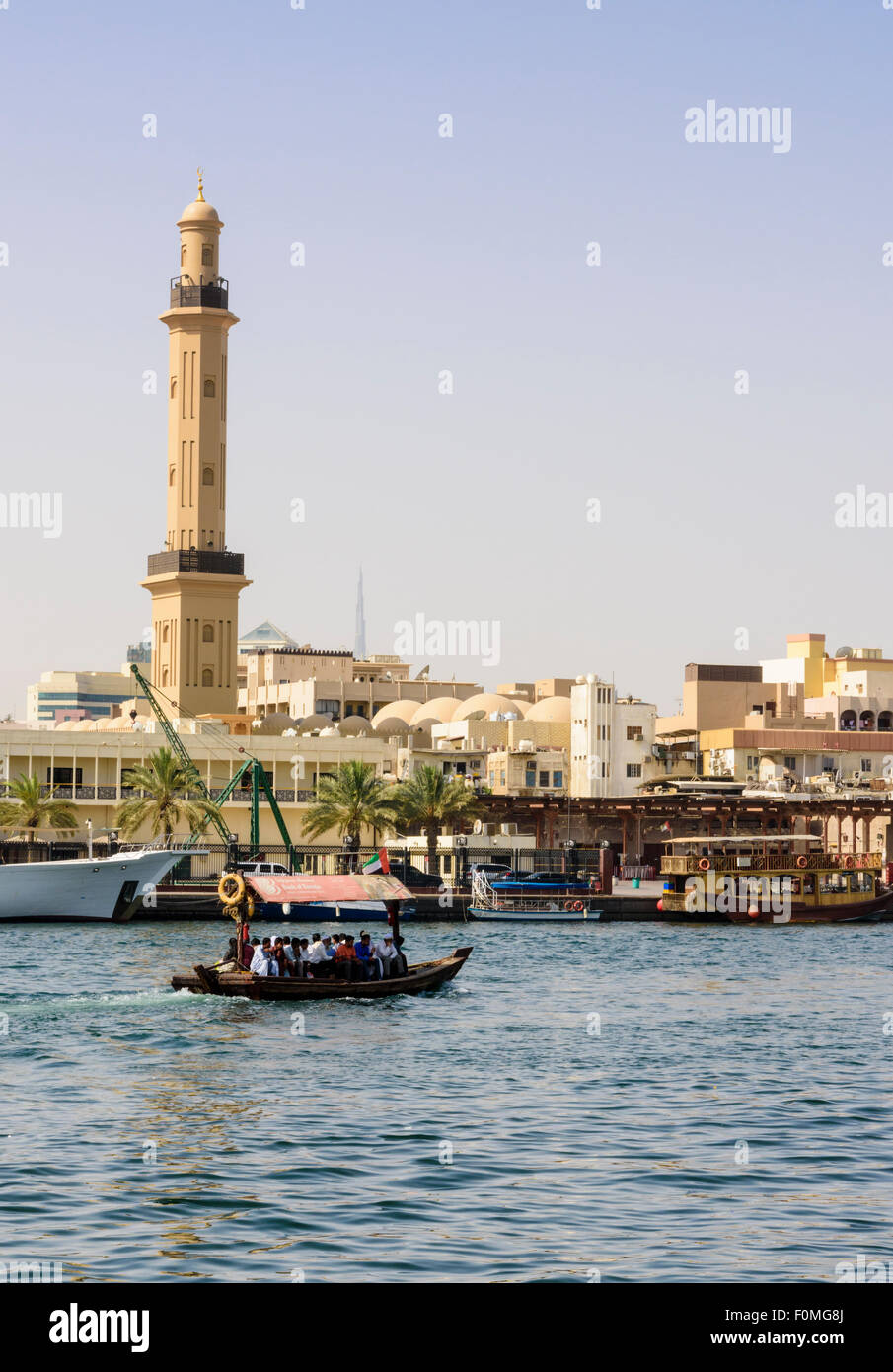 Abra boat with views over to the Grand Mosque Minaret, Dubai Creek, Deira, Dubai, UAE Stock Photo