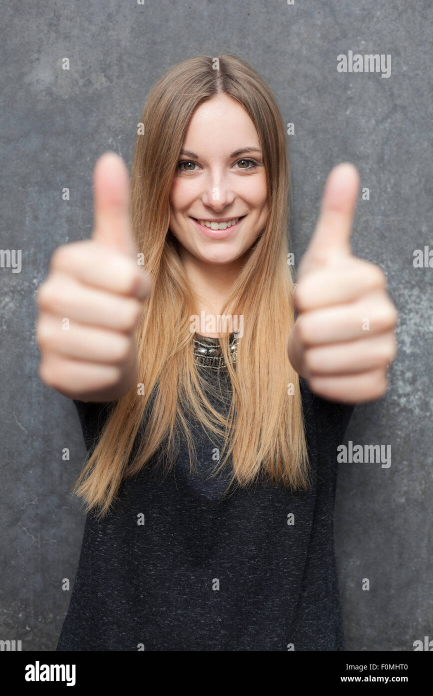 Attractive girl showing thumbs up with both hands Stock Photo