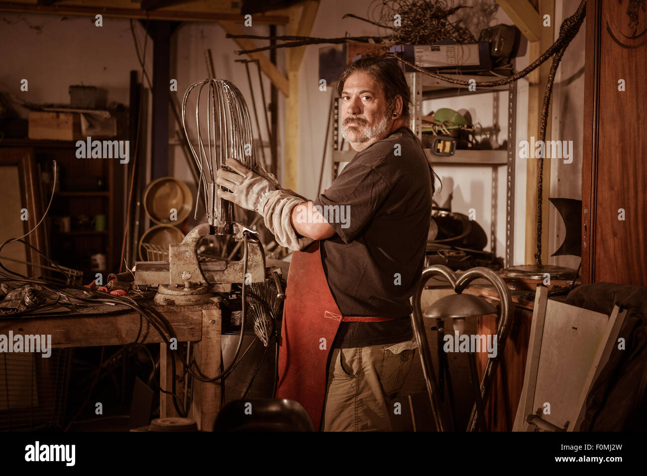 Welder wearing face mask and protective gloves in factory Stock Photo