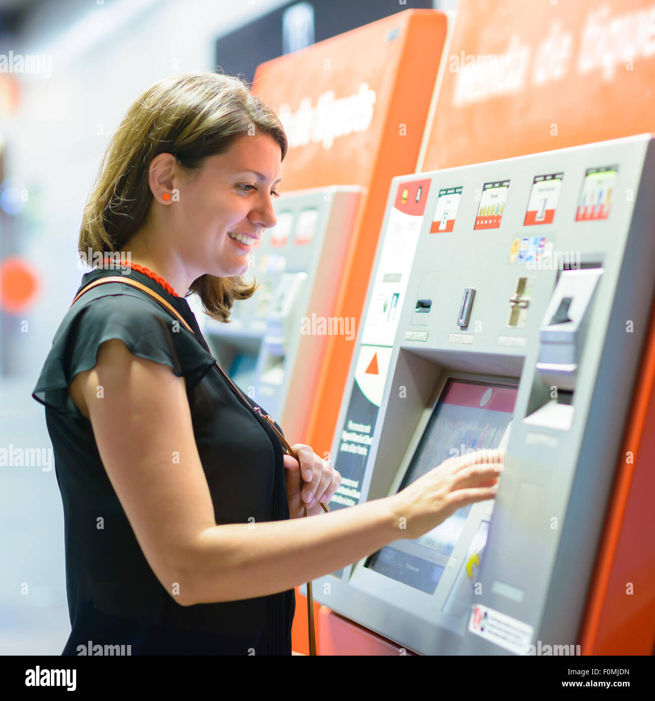 Young woman paying at ticket machine in a metro station Stock Photo