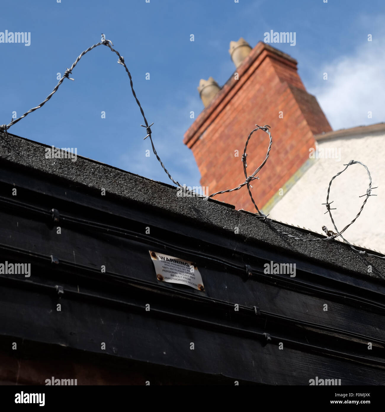 Barbed wire on top of home detached garage in town UK Stock Photo