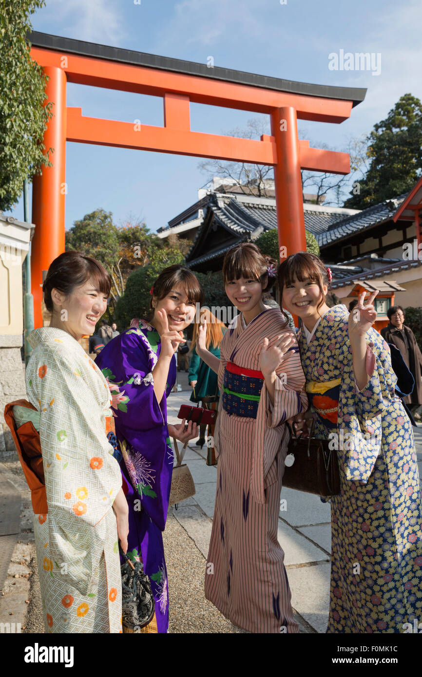 Young Japanese girls below torii gate in traditional kimonos, Yasaka Shrine, Kyoto, Japan, Asia Stock Photo